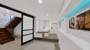 Een modern interieur met een trap, een bed met opbergruimte en een muur met een poster.