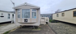 Ein Wohnmobil mit Erkerfenster, einer kleinen Veranda und einem Schild mit dem Markennamen 'SWIFT'.