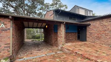 A brick building with a covered outdoor area, a garage, and a second-story structure.