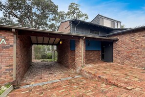 A brick building with a covered outdoor area, a garage, and a second-story structure.