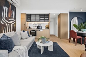 Un saló modern amb un sofà, una taula de centre i una zona de menjador amb una cadira.