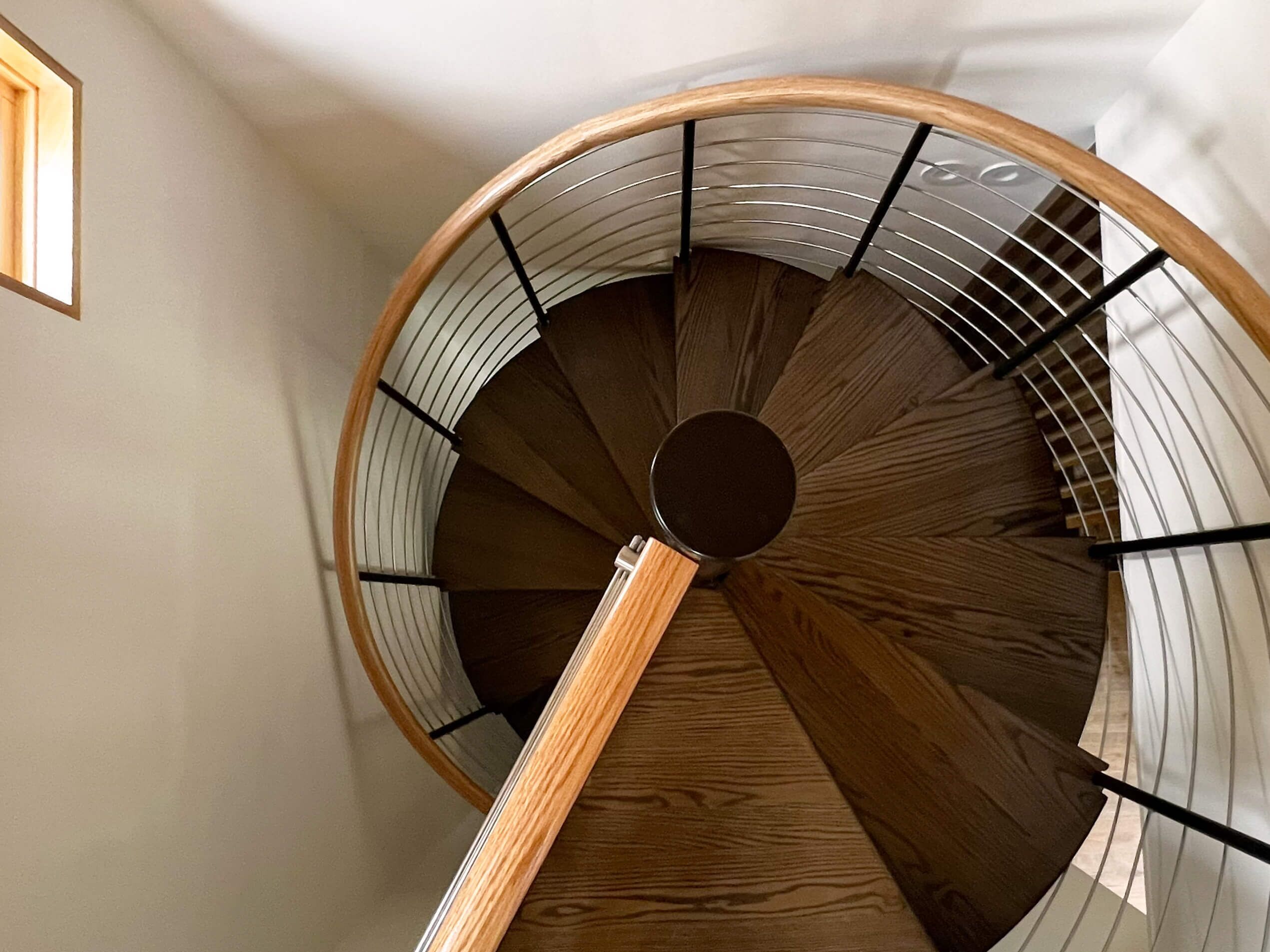 A spiral staircase with wooden steps and metal railings.