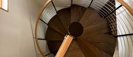 A spiral staircase with wooden steps and metal railings.