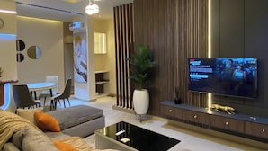 Een moderne woonkamer met een bank, salontafel, televisie en decoratieve details.