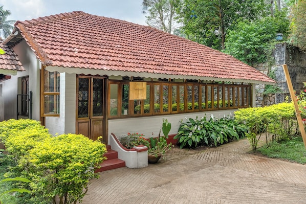 A traditional house with a tiled roof, a wooden door, and a window with a curtain.