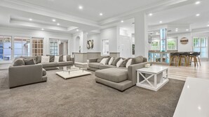 A spacious living room with a sectional sofa, a coffee table, and a dining area with chairs. - Spacious 7-Bed Family Home in Chapel Hill (Chapel Hill)
