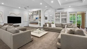 A modern living room with a flat-screen TV, a glass coffee table, and a sofa set. - Spacious 7-Bed Family Home in Chapel Hill (Chapel Hill)