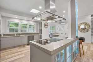 A modern kitchen with a central island, built-in appliances, and a view of the outdoors. - Spacious 7-Bed Family Home in Chapel Hill (Chapel Hill)
