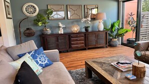Un salon comprenant un canapé, une table basse et un meuble agrémenté d’objets décoratifs.