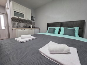 Un dormitorio con cama, baño y kitchenette.