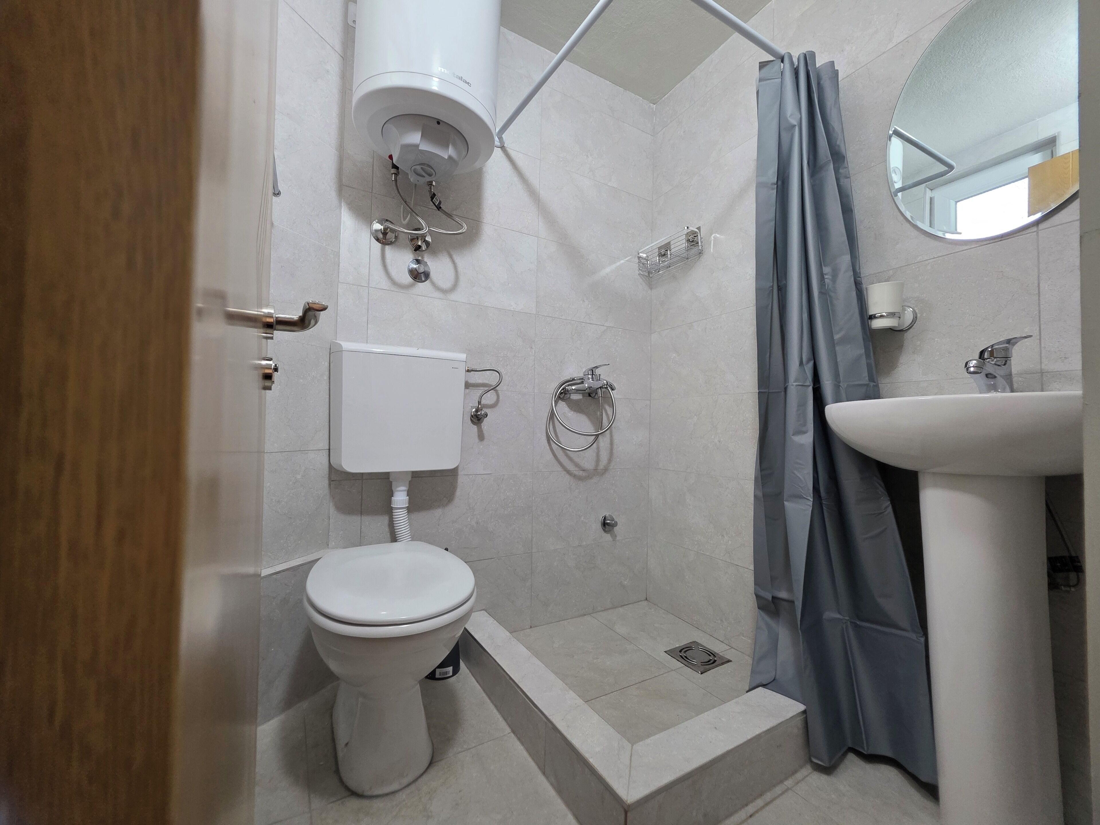 Une salle de bain avec des toilettes, une douche et un lavabo.