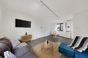 Un salon moderne avec un canapé, une table basse et un divan bleu.