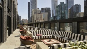 Une terrasse sur le toit avec des sièges extérieurs, une vue panoramique sur la ville et une architecture moderne.