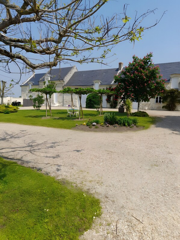 A residential property with a stone facade, a well-maintained lawn, and a gravel driveway.