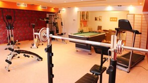 A gym with exercise equipment, a pool table, and a billiards table.