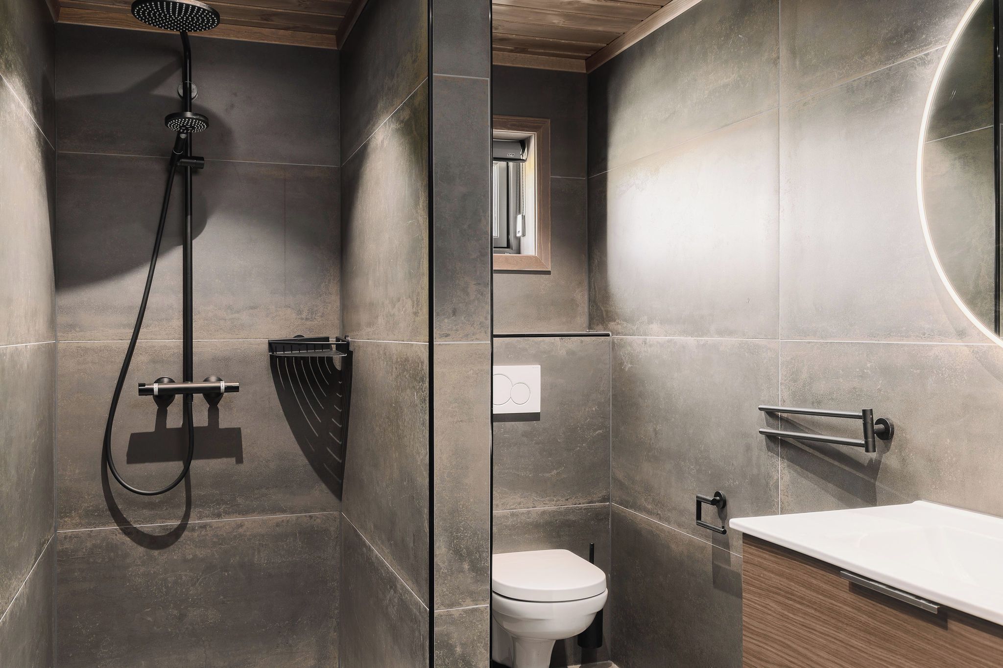 Ein modernes Badezimmer mit Dusche, Toilette und Waschtisch.
