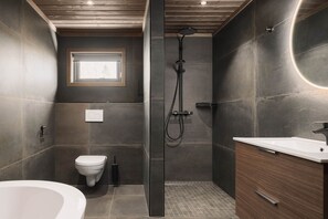 A modern bathroom with a shower, toilet, and sink.
