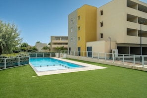A modern building with a swimming pool, surrounded by green lawns and a clear sky. - Charming Villa by Sérignan Beach (Sérignan)