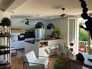 A modern kitchen with a central island, pendant lights, and a view of the outdoors. - The Blue Grotto. Stay on the blue shores of Lake Geneva, in the heart of the Alps. (Évian-les-Bains)