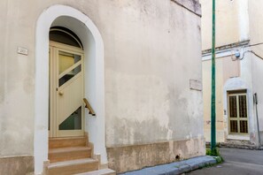 Ein Gebäude mit einer beigen Tür, einer kleinen Treppe zum Eingang und der Zahl '20' an der Wand.