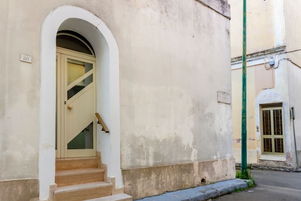Ein Gebäude mit einer beigen Tür, einer kleinen Treppe zum Eingang und der Zahl '20' an der Wand.