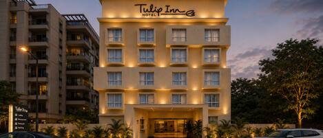 Un hotel de varios pisos con un letrero llamativo que dice 'Tulip Inn Hotel'.