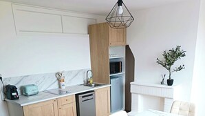 Una cocina moderna con encimera de mármol, armarios de madera y lavavajillas integrado.