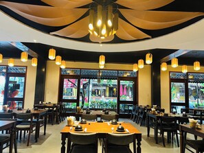 A restaurant with tables and chairs, large windows, and hanging lanterns. - Happy Life Heritage Hoi An Hotel (Minh An)