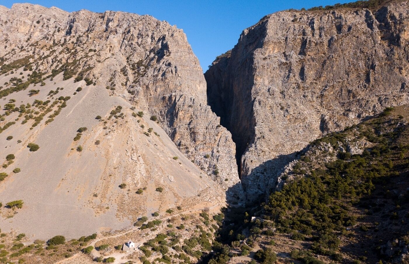A mountainous landscape with rocky cliffs and sparse vegetation.