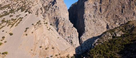 A mountainous landscape with rocky cliffs and sparse vegetation.