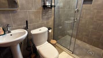 Un bagno con lavandino, servizi igienici, doccia e porta asciugamani.