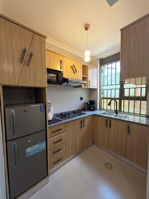 Una cocina moderna con armarios de madera, horno empotrado, cocina a gas y una ventana con vistas.