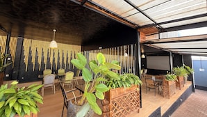 A modern indoor space with a high ceiling, wooden flooring, and multiple seating areas. - Elite Apartments (Kigali)