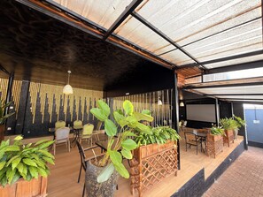 Un espacio interior moderno con techo alto, piso de madera y varias zonas de estar.
