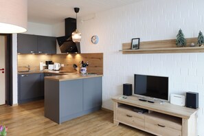 Eine moderne Küche mit Kochinsel, integrierten Geräten und einem Essbereich aus Holz.