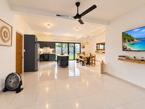A spacious kitchen with a dining area, a ceiling fan, and a large window overlooking a scenic view. - 3 bedroom villa,5 minutes to the main beach driving 3 minute to other beach (Cabarete)
