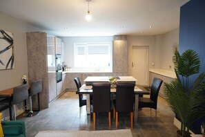 Een moderne keuken met een eethoek, een bar en een groot raam.