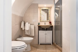 A bathroom with a toilet, bidet, sink, mirror, and shower. - Holiday Home 'Fioredoro' with Air Conditioning (Martina Franca)