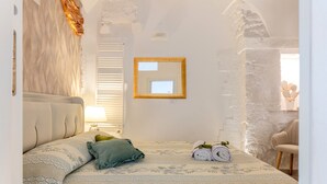 A bedroom with a bed, a mirror, a lamp, and a chair. - Fioredoro Holiday Home with Air Conditioning (Martina Franca)