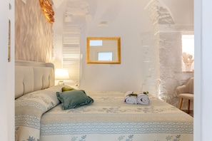 A bedroom with a bed, a mirror, a lamp, and a chair. - Holiday Home 'Fioredoro' with Air Conditioning (Martina Franca)