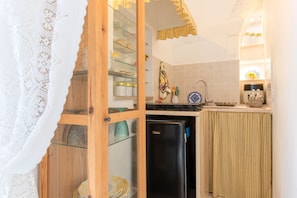 A compact kitchen with a refrigerator, a sink, and a glass cabinet with dishes. - Holiday Home 'Fioredoro' with Air Conditioning (Martina Franca)