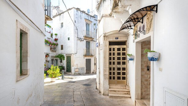 A narrow street with a door, a window, and a wall with a decorative arch. - Fioredoro Holiday Home with Air Conditioning (Martina Franca)