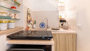 A kitchen with a built-in stove, a sink, and shelves with kitchenware. - Fioredoro Holiday Home with Air Conditioning (Martina Franca)