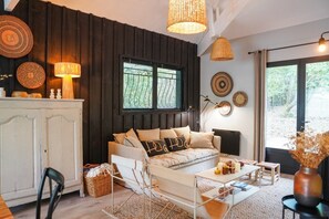 Un salon chaleureux avec un canapé, une table basse, un meuble et des assiettes décoratives accrochées au mur.