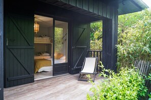 Une cabane en bois avec un lit, une chaise et une vue sur la verdure.