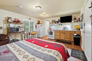 A compact living space with a bed, kitchenette, and a TV. - Whittier Cabin Retreat for Large Groups (Whittier)