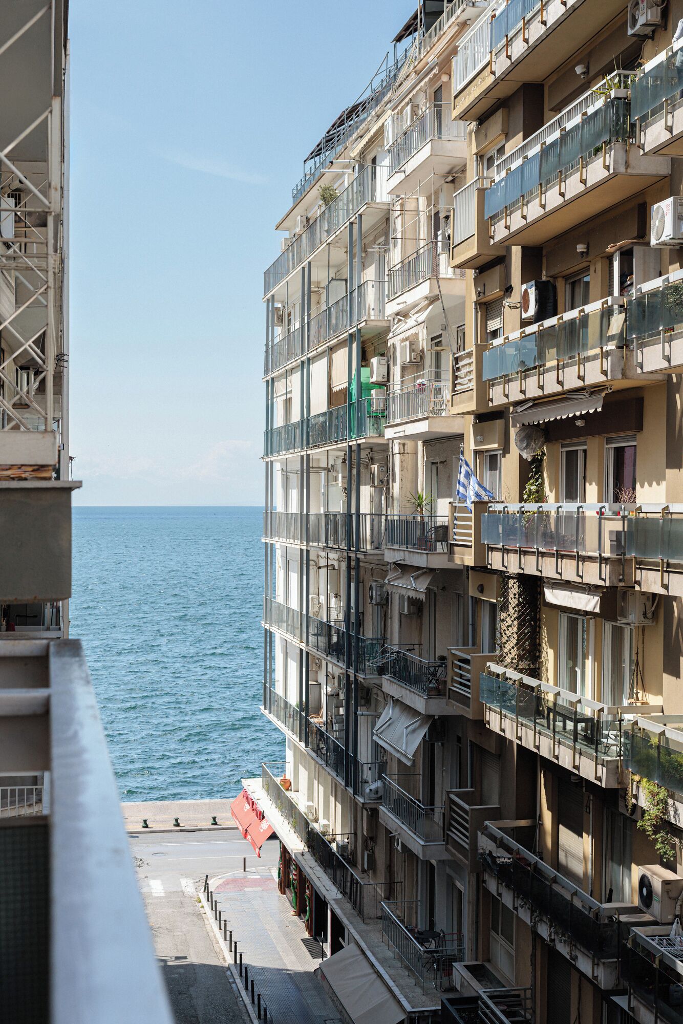 A multi-story building with balconies overlooking the sea.