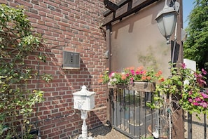 A brick building with a mailbox, a bird feeder, and a flower planter.