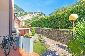 A courtyard with a stone wall, a small garden, and a mountain backdrop.