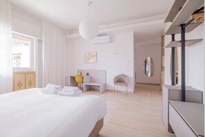 Una camera d'albergo con un letto, una scrivania, una sedia, un armadio e una televisione.